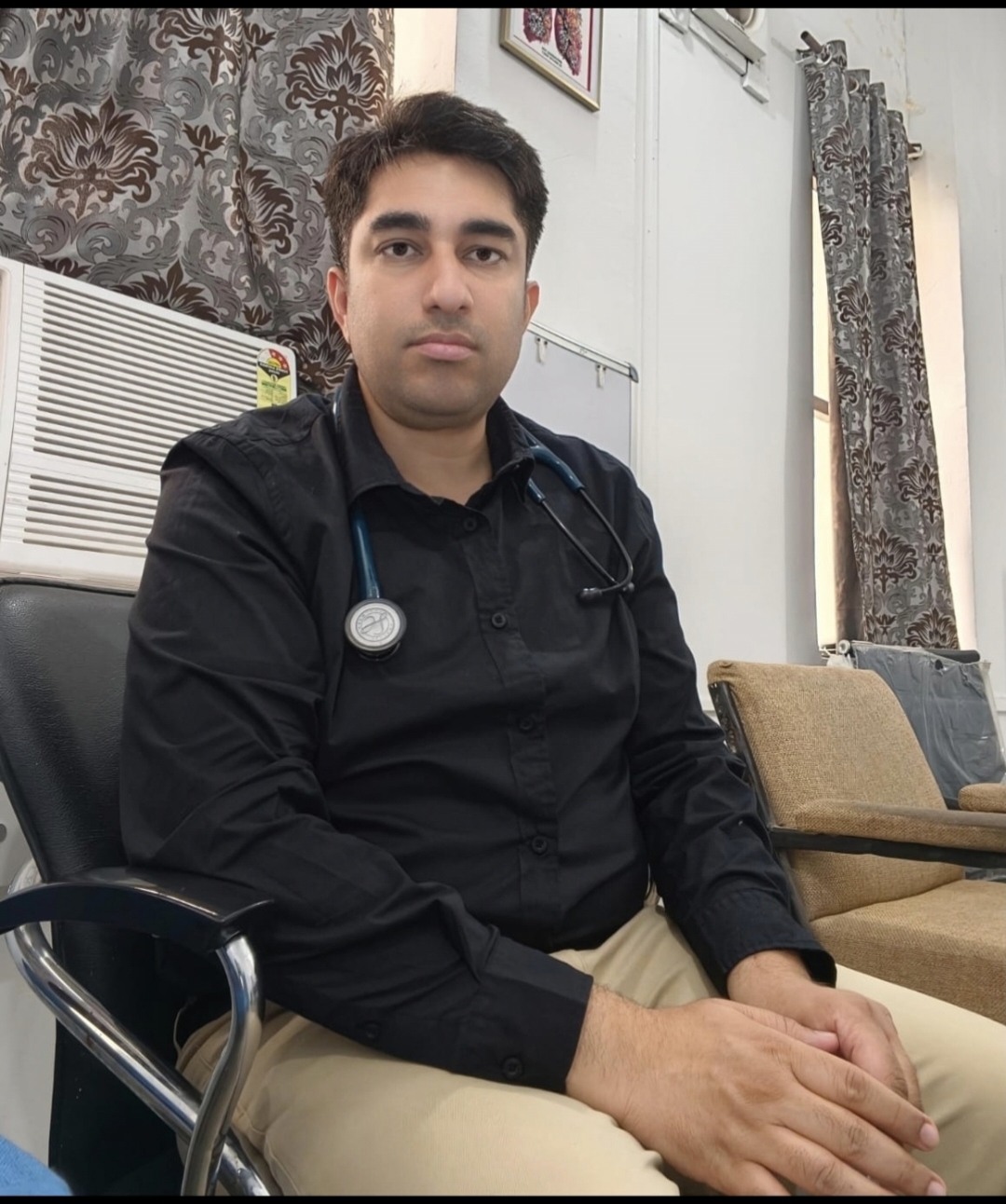 Dr. Neeraj Mumwalia MBBS MD Pulmonology specialist seated in clinic wearing white coat